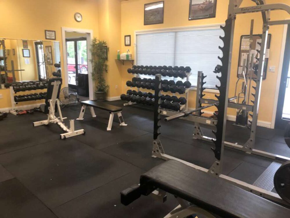 Free-weight room with dumbbells, benches and racks